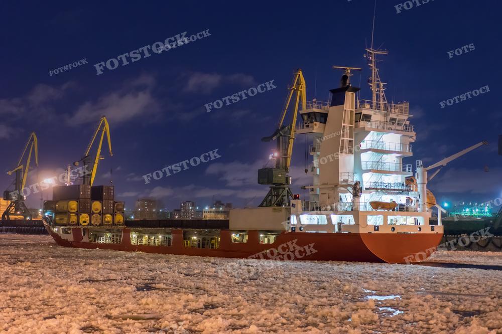 На фотографии изображено грузовое судно, окруженное льдом. Этот снимок иллюстрирует суровые условия морской навигации в холодных регионах, где суда сталкиваются с преградами льда.
